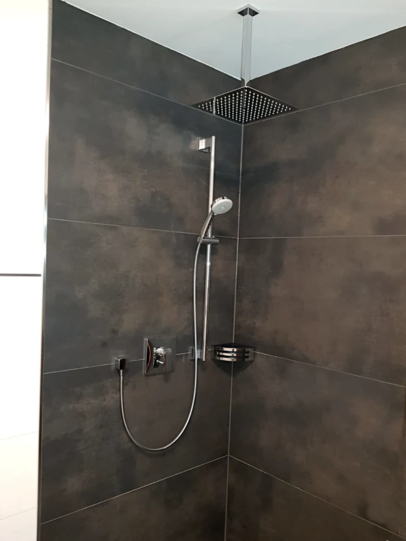 Dusche mit Regenduschkopf und Handbrause Dusche mit Regenduschkopf und Handbrause, dunkle Fliesen